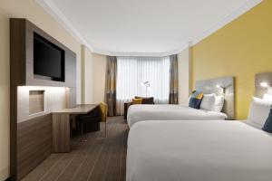 雪梨的住宿－Sydney Central Hotel Managed by The Ascott Limited，酒店客房设有两张床和电视。