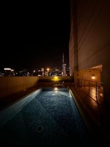 een zwembad aan de zijkant van een gebouw 's nachts bij Business bay in Dubai