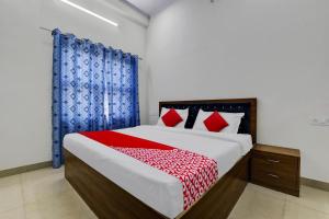 1 dormitorio con 1 cama grande y cortinas rojas y azules en OYO Hotel Ishwar en Jaipur