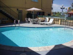a pool with a pool table and chairs in it at Townhouse Inn and Suites in Brawley