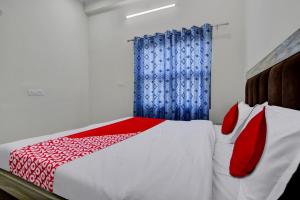 1 dormitorio con 1 cama con cortina roja y azul en OYO Hotel Ishwar en Jaipur