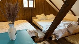 1 dormitorio con 1 cama y un jarrón sobre una mesa en Roubenka Ratměřice - Garni Ratmerice, en Ratměřice