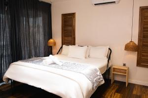 1 dormitorio con 1 cama blanca grande con almohadas blancas en Ulo Lagos, en Lekki