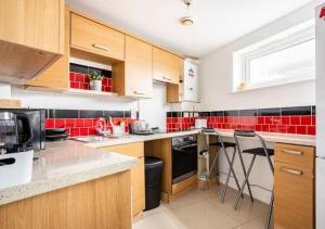 a kitchen with red tiles on the wall at The Dartford Lodge in Kent