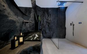een badkamer met een douche en een glazen wand bij Million Stars Mykonos in Mykonos-stad