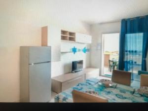 Una cocina con una mesa y un refrigerador en una habitación. en Castelsardo, en Castelsardo