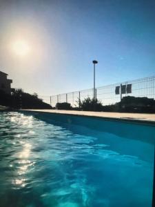 una piscina de agua azul frente a una valla en Castelsardo, en Castelsardo
