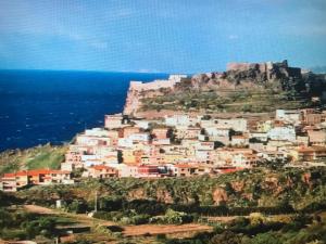 una ciudad en una colina junto al océano en Castelsardo, en Castelsardo