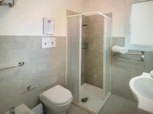 Un baño con ducha, inodoro y lavabo. en Castelsardo, en Castelsardo