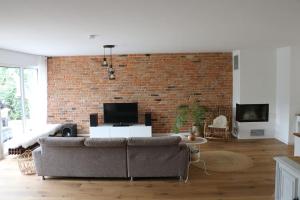 a living room with a couch and a brick wall at Gemütliches Traumhaus im Grünen in Swisttal