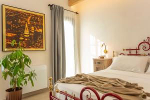 ein Schlafzimmer mit einem Bett, einer Pflanze und einem Fenster in der Unterkunft ALFA COUNTRY HOUSE Villa Salento in Lequile