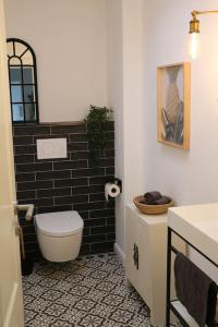 a bathroom with a toilet and a black tile floor at Gemütliches Traumhaus im Grünen in Swisttal