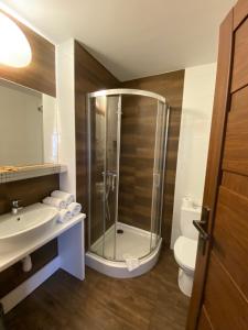 a bathroom with a shower and a sink and a toilet at Hotel Constancja in Częstochowa