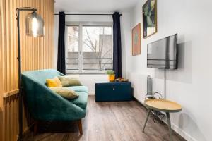 a living room with a green couch and a tv at Studio cosy avec parking in Lyon