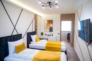 a hotel room with two beds with yellow sheets at IMPERIAL STUDIO in Sibiu