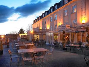 um pátio exterior com mesas e cadeiras em frente a um edifício em Bridge House Hotel, Leisure Club & Spa em Tullamore