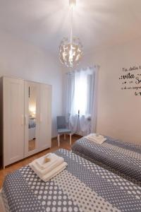 1 dormitorio con 2 camas individuales y lámpara de araña en Casa vacanze Il Pugnalone, en Acquapendente