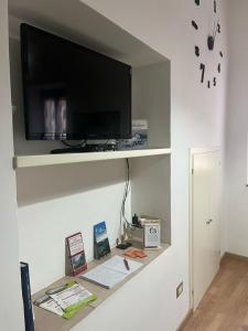 estante con TV en la pared y escritorio en Casa vacanze Il Pugnalone, en Acquapendente