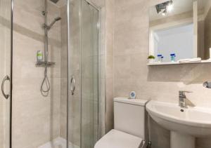 a bathroom with a shower and a toilet and a sink at The Dartford Lodge - Free Parking in Kent