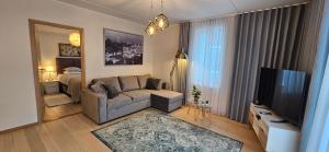ein Wohnzimmer mit einem Sofa und einem TV in der Unterkunft Jakobsoni 7 Apartment in Tallinn