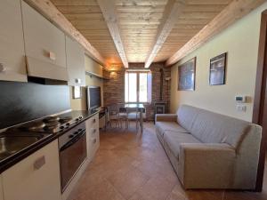 a living room with a couch and a kitchen at Affittimoderni Ponte di Legno Ski in Ponte di Legno