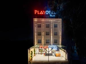 a hotel with a neon sign on top of it at Playotel Inn, Chandigarh in Zirakpur