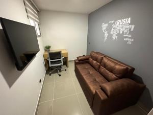 a living room with a couch and a television at Apartamento parque de Envigado in Envigado