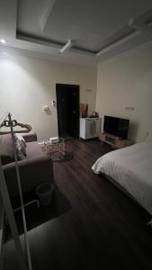 1 dormitorio con cama, sofá y TV en استيديو بالعقيق بدخول ذاتي c3, en Riad