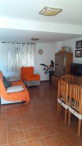 uma sala de estar com uma cama laranja e uma mesa e cadeiras em Sol y playa em Puçol