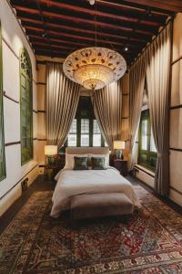 a bedroom with a large bed and a chandelier at Al Balad Hospitality in Jeddah
