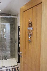 una puerta que da a un baño con ducha y una puerta de cristal en The Old Lifeboat Station of Hoylake, en Hoylake