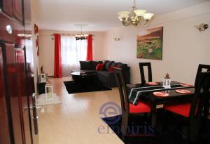 a living room with a black couch and a table at 1BR Luxury Apartment Milimani Nakuru, Empiris with Pool, Gym, Near Golf Club in Nakuru