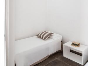 a white bedroom with a bed and a side table at Relais San Martino Salento - Handwritten Collection in Taviano