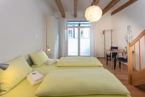 1 dormitorio con 2 camas, escritorio y mesa en Pensionsieben Das andere Hotel, en Lörrach
