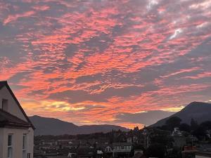 a sunset over a city with buildings and mountains at Town centre property convenient for the fells in Keswick