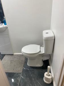 a bathroom with a toilet and a sink at Jmk home in Lexden