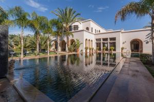 a house with a swimming pool in front of it at Palais FARAH in Marrakesh