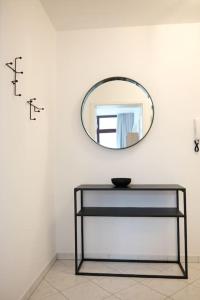 a mirror on a white wall with a black table at Schickes Apartment in Zwickau direkt am Römerplatz in Zwickau