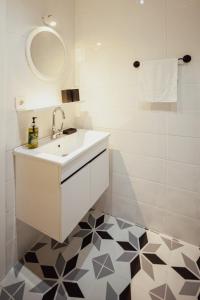 a white bathroom with a sink and a mirror at Uraya Suites in Istanbul