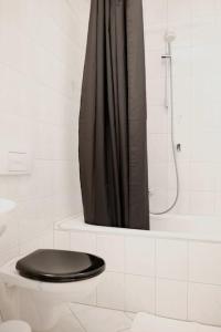 a bathroom with a toilet with a black shower curtain at Schickes Apartment in Zwickau direkt am Römerplatz in Zwickau