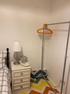 a bedroom with a bed and a lamp and a dresser at Jmk home in Lexden