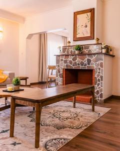 a living room with a table and a fireplace at Silverbeck Residence, Nanyuki in Nanyuki