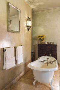 a bathroom with a white tub and a mirror at Mount High Luxury Country Estate in Lydenburg