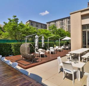 a deck with tables and chairs on a building at Love Luxe @ Sandton skye in Johannesburg