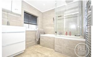 bagno con doccia, vasca e lavandino di Immaculate 3-Bed House in Bungay a Bungay