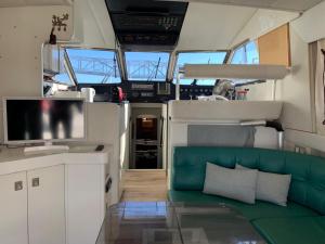 una sala de estar con un sofá verde en un barco en Barco Barcelona en Barcelona