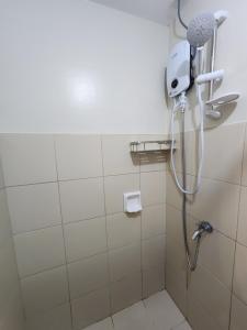 La salle de bains est pourvue d'une douche avec un pommeau de douche. dans l'établissement 2BR NORTHPOINT CONDO Free Airport Pick up, à Davao