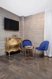 a living room with two chairs and a table and a tv at Hotel Los Girasoles in Granada