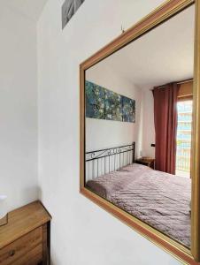 un grande specchio appeso a una parete con un letto di Appartamento di Matteo e Luisa a Perugia