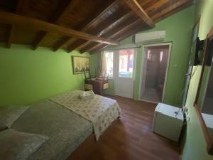アンタルヤにあるCamel Hotel & Apartの緑の壁のベッドルーム1室、ベッド1台が備わります。